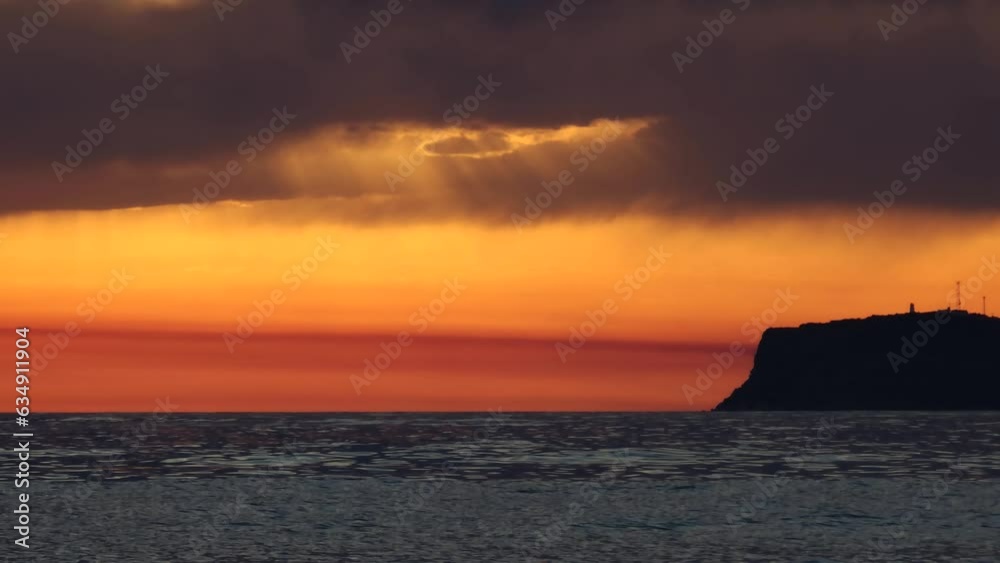 Red sunset island silhouette with colorful sky sunlight reflecting on sea surface, romantic evening in Mediterranean Red sunset island silhouette with colorful sky sunlight reflecting on sea surface, romantic evening in Mediterranean