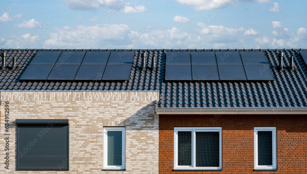 Newly build houses with black solar panels on the roof against a sunny sky Close up of new building with black solar panels. Zonnepanelen, Zonne energie, Translation: Solar panel, , Sun Energy Newly build houses with black solar panels on the roof against a sunny sky Close up of new building with black solar panels. Zonnepanelen, Zonne energie, Translation: Solar panel, , Sun Energy