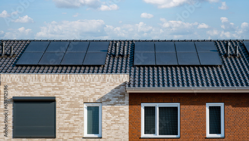 Newly build houses with black solar panels on the roof against a sunny sky Close up of new building with black solar panels. Zonnepanelen, Zonne energie, Translation: Solar panel, , Sun Energy