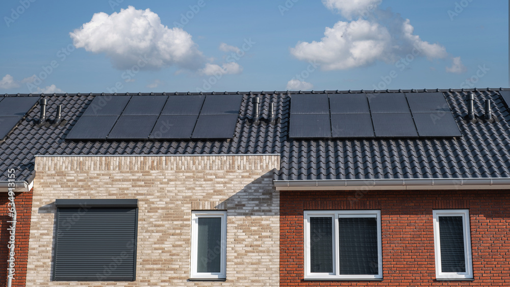 Newly build houses with solar panels attached on the roof Close up of new building with black solar panels. Zonnepanelen, Zonne energie, Translation: Solar panel, , Sun Energy Newly build houses with solar panels attached on the roof Close up of new building with black solar panels. Zonnepanelen, Zonne energie, Translation: Solar panel, , Sun Energy