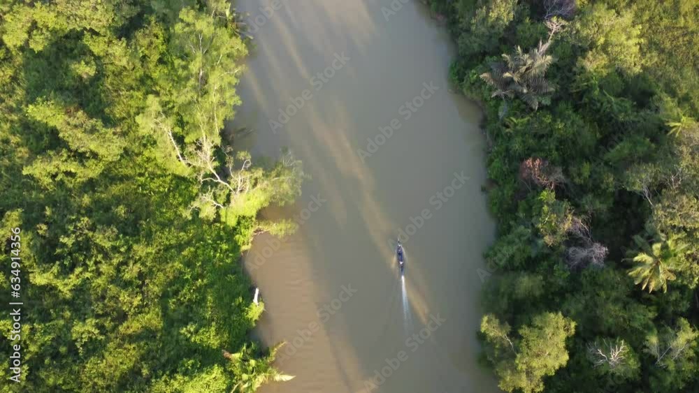 Aerial view of an engine boat passing through a river with brown river water