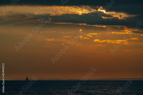 Sunset with cloudy sky above Cleveland Ledge Lighthouse in Buzzards Bay on cape cod