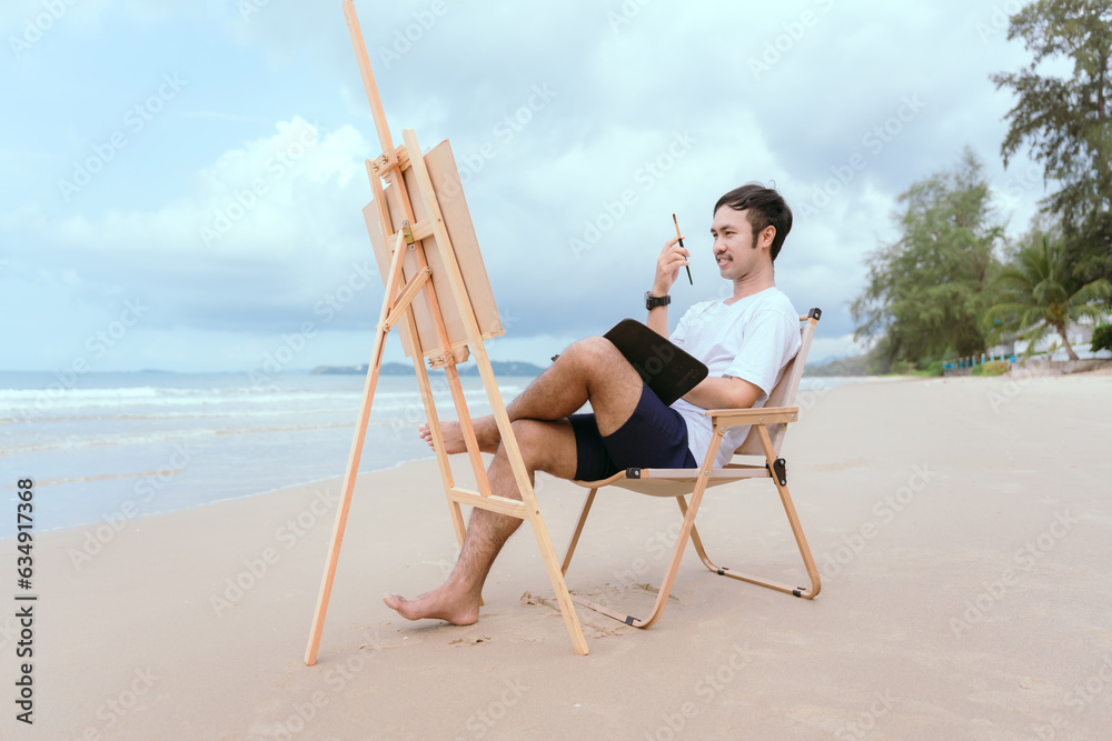 Hanumnang man relaxing by the sea in the morning sit and paint with watercolors as a hobby