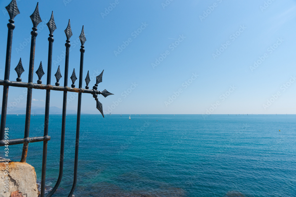 Wrought iron decorative barrier on edge Mediterranean sea landscape to horizon at Antibes