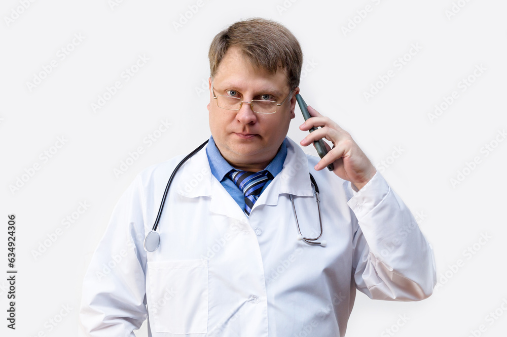 The doctor shows with gestures that calling on a smartphone, the concept of a medical consultation on the phone. The doctor shows with gestures that calling on a smartphone, the concept of a medical consultation on the phone.