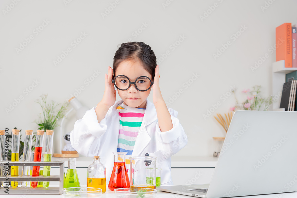 Asian little girl working with test tube science experiment in white classroom Asian little girl working with test tube science experiment in white classroom