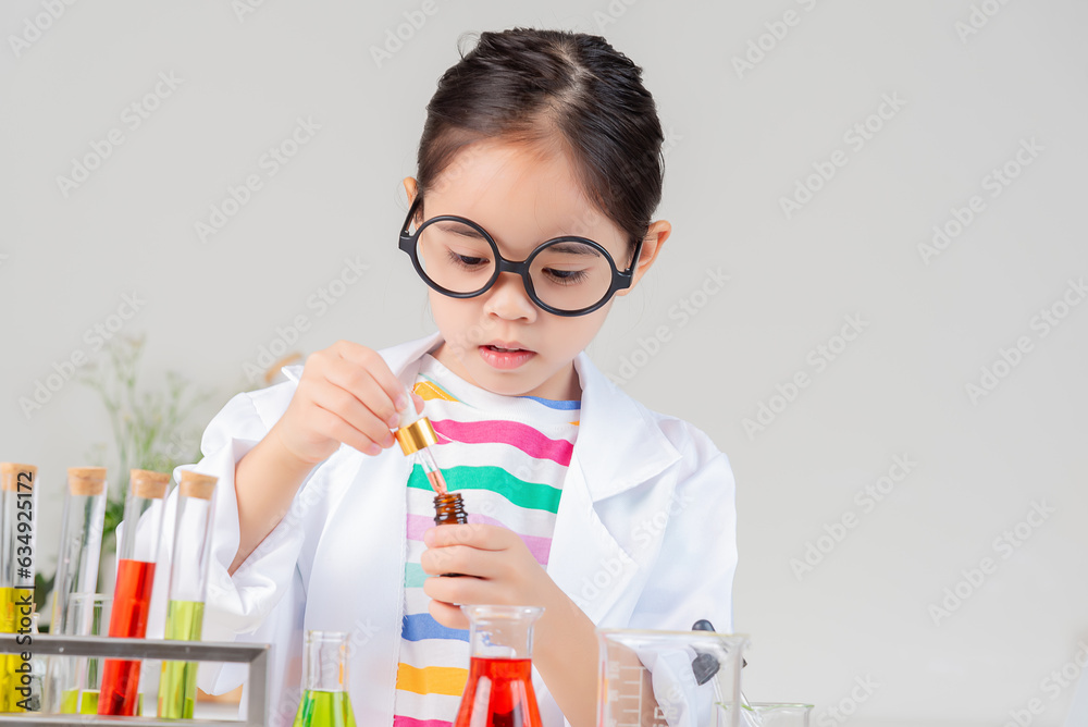 Asian little girl working with test tube science experiment in white classroom Asian little girl working with test tube science experiment in white classroom
