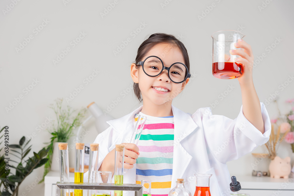 Asian little girl working with test tube science experiment in white classroom