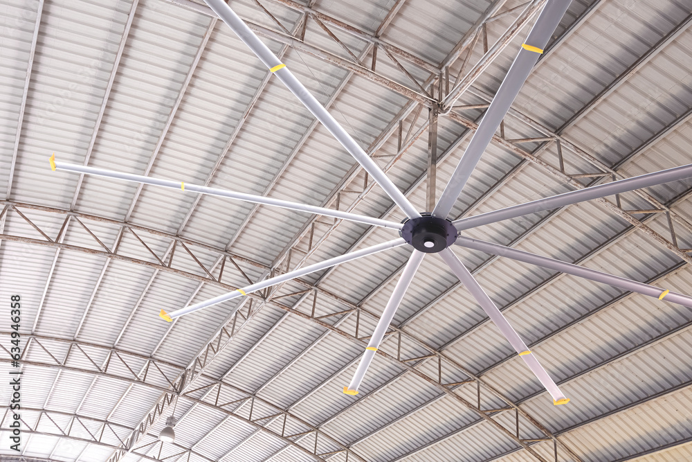 Steel Rising Block With Fan HVLS big fan on ceiling under the old metal curve roof structure of ...