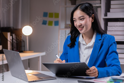 Asian business woman working late at night in office workplace. doing planning analyzing the financial report, business plan investment, finance analysis, Overtime work concept,  © David