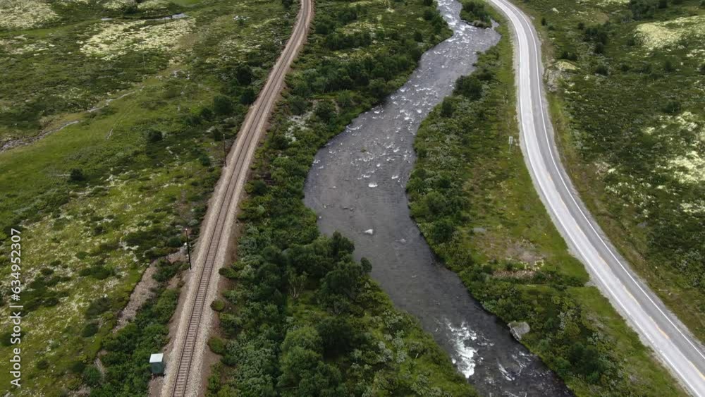 Traintracks next to river on top of mountain drone Traintracks next to river on top of mountain drone