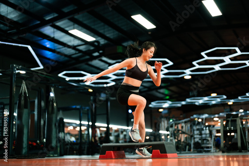 Fotografie Young Sportive Woman Workout Exercising with Step Platform at Fitness Center or Gym