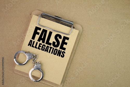 handcuffs and a blackboard with the words false allegations. the concept of false allegations. concept of justice photo