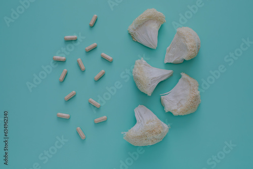 Top view of lions mane mushroom and supplement pills on aqua blue background. Cognitive Health concept photo