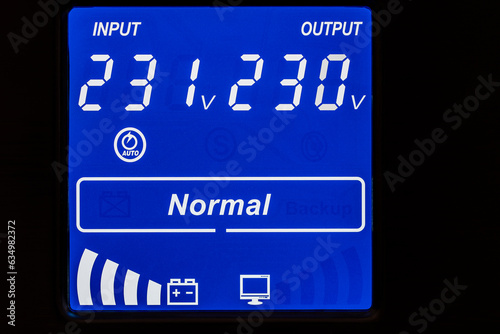 Closeup of blue digital display on uninterruptible power supply with automatic voltage stabilizer