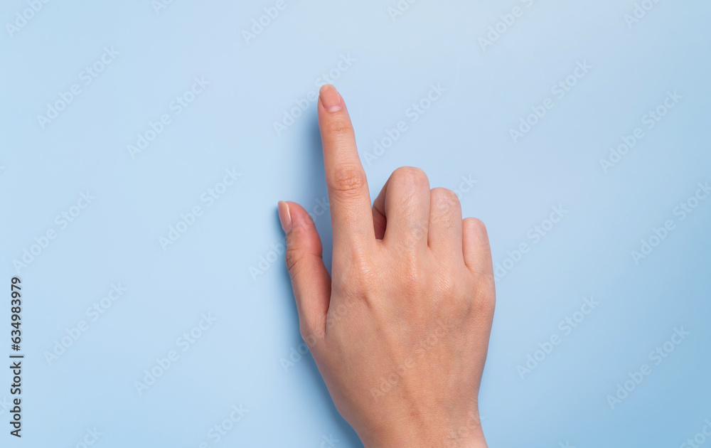 Close up of female hand pointing on isolated blue background