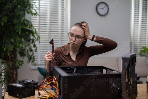 Office worker strenuously tries to fix broken computer photo