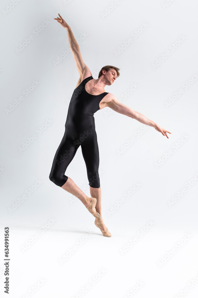 Ballet Dancer Young Athletic Man in Black Suit Posing in Ballanced Stretching Dance Pose Studio On White.