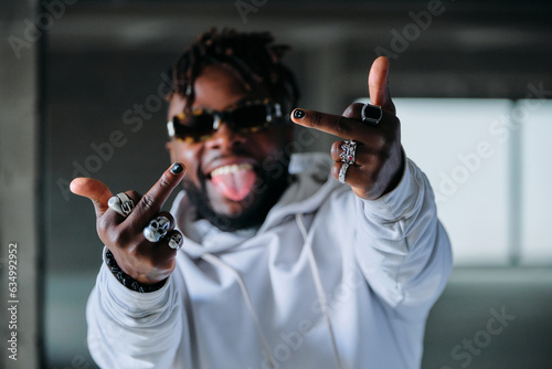 Cheerful stylish man showing middle finger