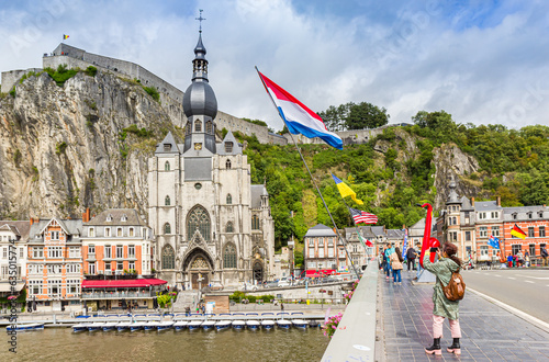 Canvas Print Tourists at the bridge with national flags in Dinant, Belgium