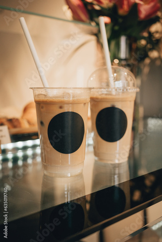 Two cups of fresh iced coffee on café glass counter top.	
