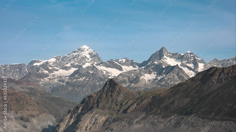 rocky and snowy mountains during sunrise in time lapse with bright blue sky near monte rosa hut, Switzerland rocky and snowy mountains during sunrise in time lapse with bright blue sky near monte rosa hut, Switzerland