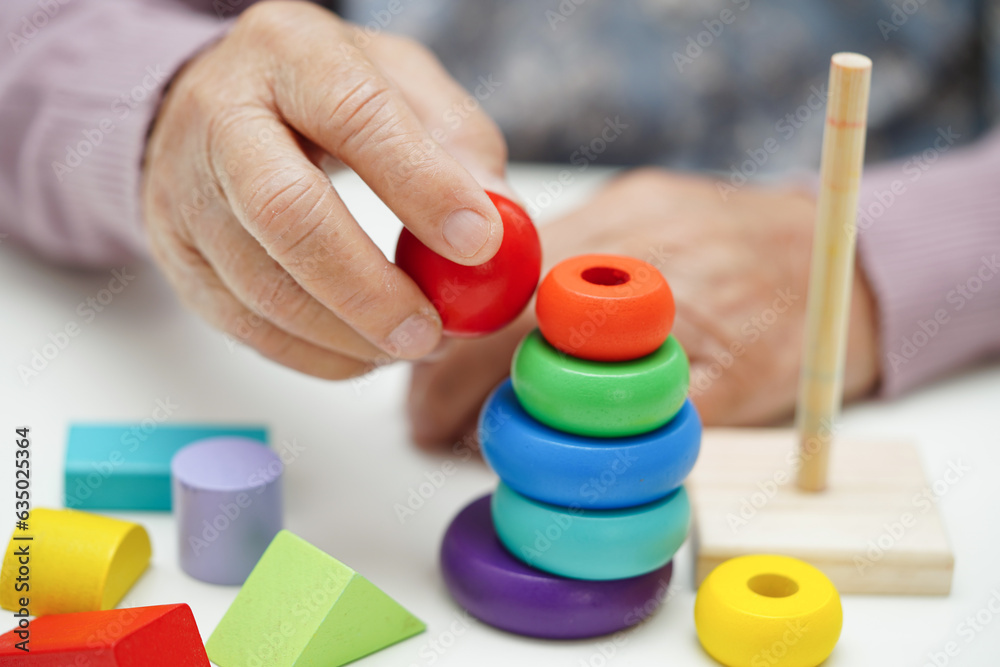 Asian elderly woman playing puzzles game to practice brain training for dementia prevention, Alzheimer disease. Asian elderly woman playing puzzles game to practice brain training for dementia prevention, Alzheimer disease.