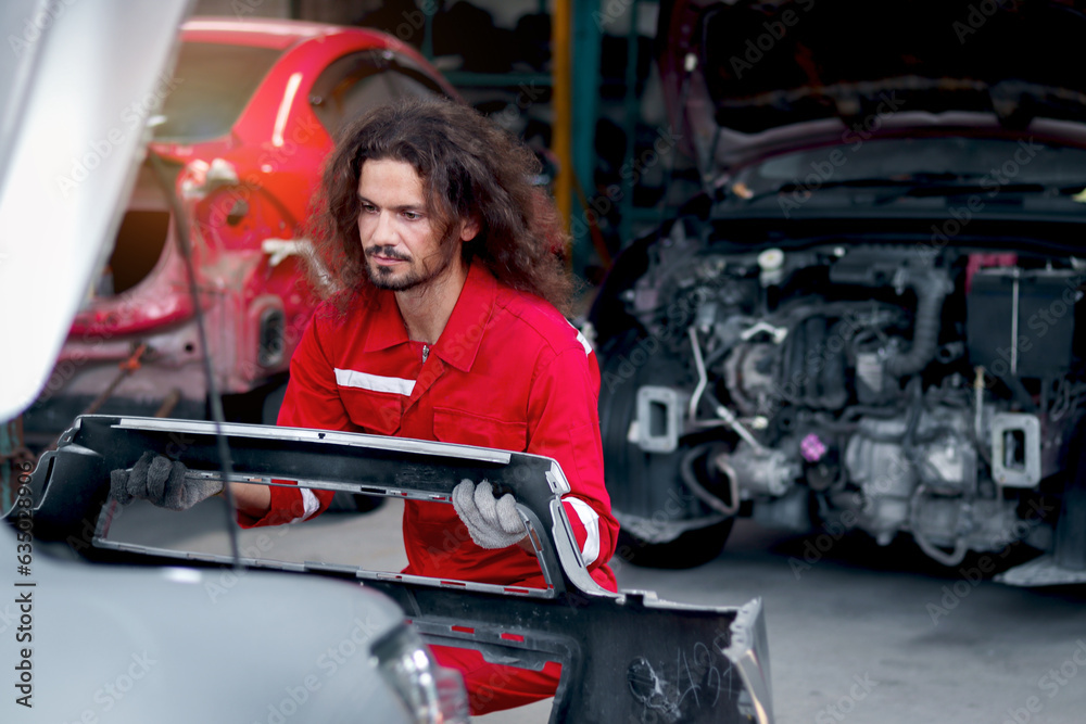 Long hair handsome mechanic man in red uniform works with engine vehicle, auto mechanic technician inspecting maintenance engine system of customer car automobile at garage car repair service shop. Long hair handsome mechanic man in red uniform works with engine vehicle, auto mechanic technician inspecting maintenance engine system of customer car automobile at garage car repair service shop.
