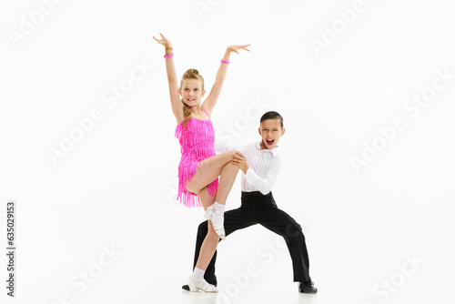 Photography Beautiful, stylish children boy and girl dancing retro style dance, performing against white studio background