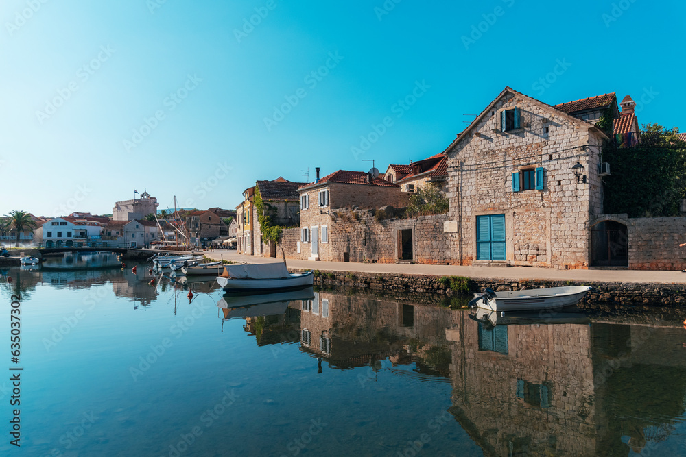 Vrboska village embankment, houses are reflected in the water. Hvar island, Croatia
