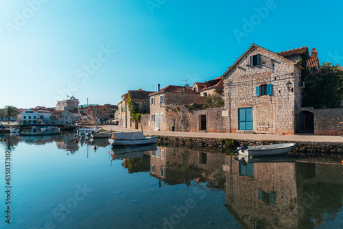 Vrboska village embankment, houses are reflected in the water. Hvar island, Croatia
