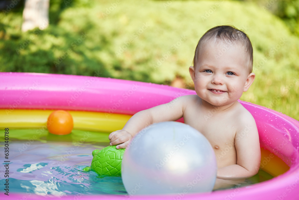 Obraz premium cute baby girl swimming in kid inflatable pool