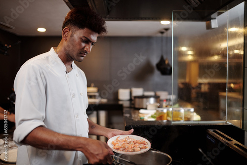 Fototapeta Naklejka Na Ścianę i Meble -  Cook boiling shrimps when making appetizer for restaurant guests