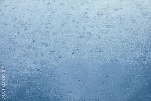 Background water surface with circles of raindrops. Water ripple texture.
