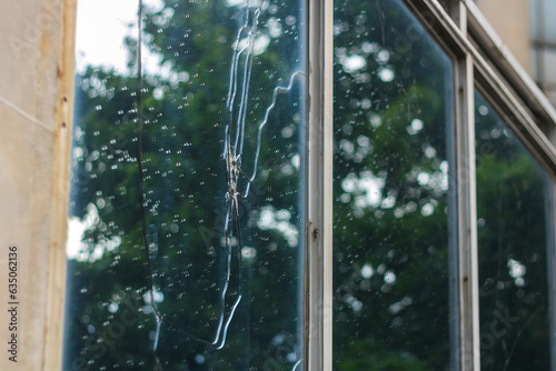 Broken window glass with rain drops. Office building damaged by war drone. Act of terrorism. Destroyed civil infrastructure