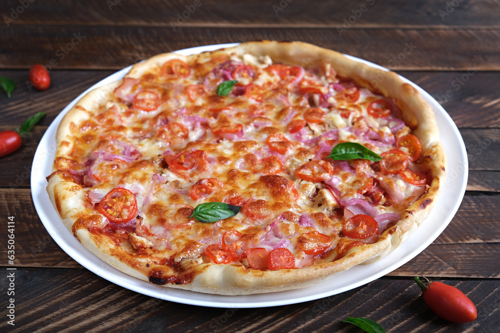 Italian pizza with ham, chicken, tomatoes and cheese.