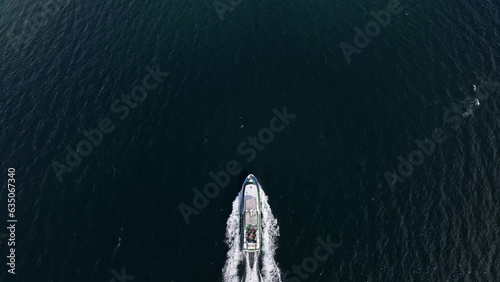 Drone overtaking charter tourist boat in birdseye perspective - Aerial above boat cruising the fjords of Norway photo