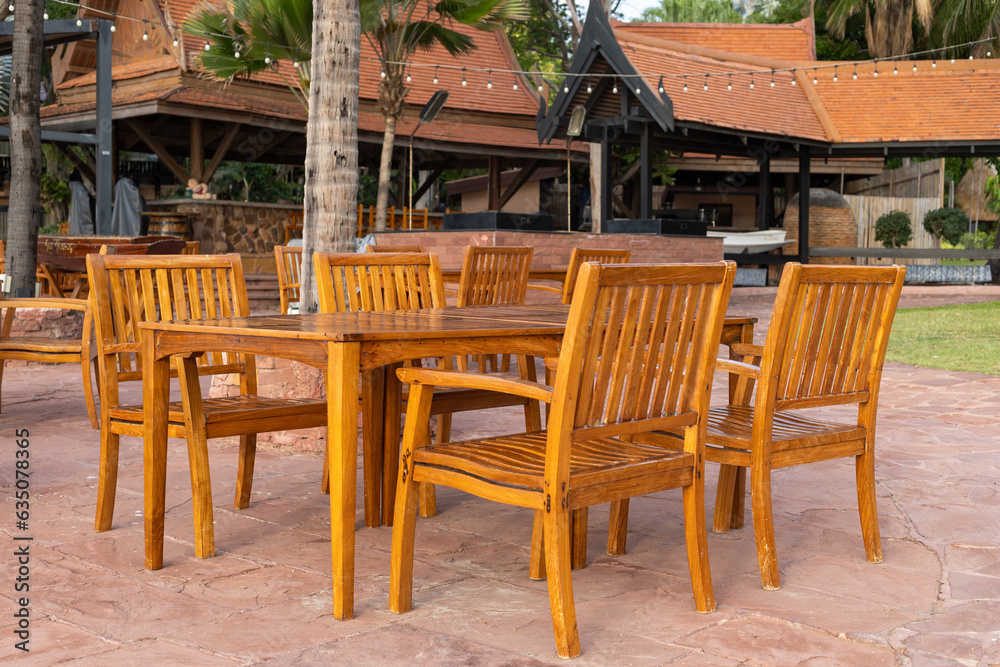 outdoor restaurant at the dining table sea view on beach, wood chairs and table