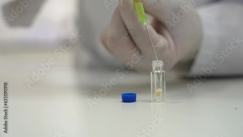 Precision in Action: Filling a Container with Orange Liquid Using a Syringe
