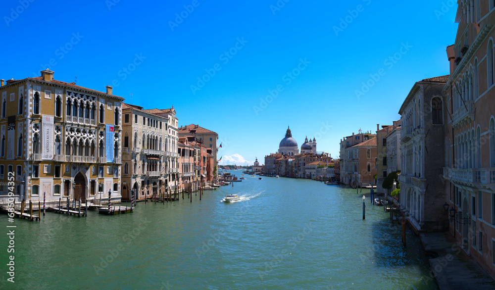 Wide angle scenic view over Grand Canal at the old town of Venice seen from Accademia Bridge on a sunny summer day. Photo taken August 7th, 2023, Venice, Italy.