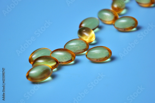 Yellow pills, vitamins on a blue background, medical background