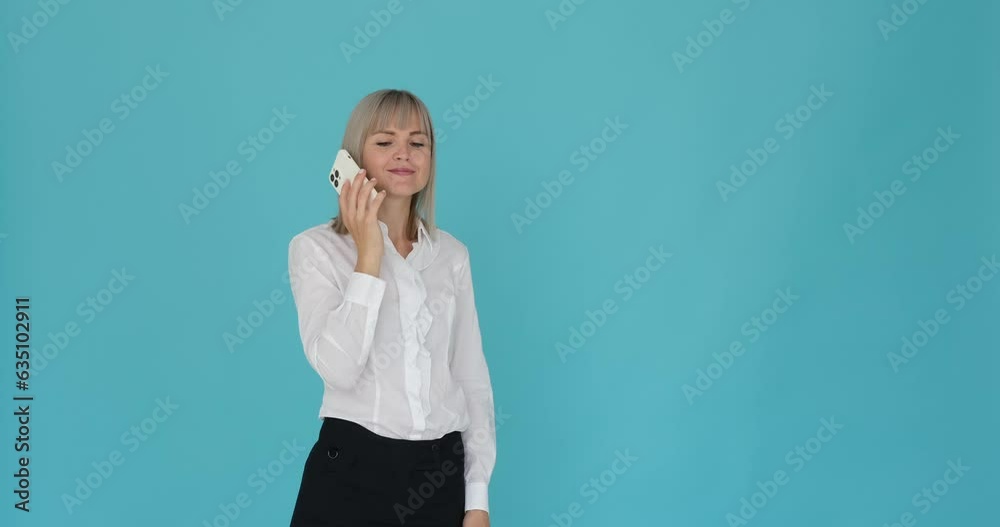 Composed woman having a conversation on her phone and smiling with contentment on a serene blue background. Her serene expression and the smile on her face suggest a sense of tranquility. Composed woman having a conversation on her phone and smiling with contentment on a serene blue background. Her serene expression and the smile on her face suggest a sense of tranquility.