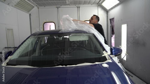 Kyiv, Ukraine - August 12, 2023: Paint shop at the car service station. The master of the paint shop prepares the car for painting. Painting a car in a paint booth