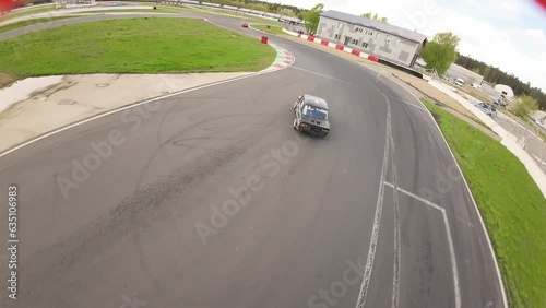aerial filming of a circuit race on an asphalt circuit, fpv drone, racing cars go fast, time trials, sharp turns