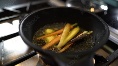 Root vegetables added to pan of bubbling butter photo