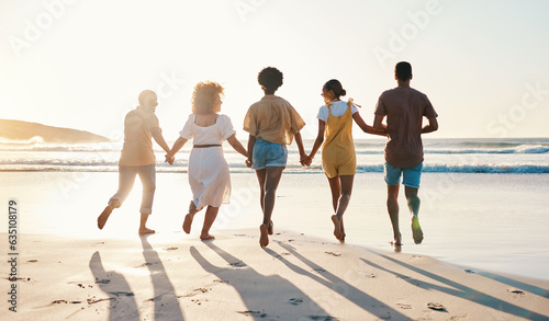 Friends, holding hands and running at sunset on beach in summer, vacation or walking together on holiday break with freedom. Group, silhouette and people with connection and support in community