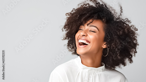 Beautiful african american girl with an afro hairstyle smiling. Smiling beautiful afro girl. Curly black hair. Emotion concept.
