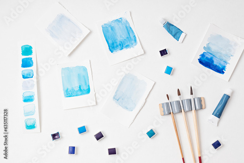 Artist painting watercolor palettes in blue pastel with brushes. Craft artistic background. Recomforting, destressing hobby, art photo