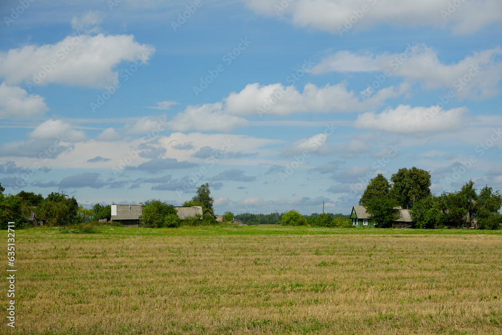 Farm harvested field. Beautiful clouds in the blue sky. horizon. Summer. August. Village