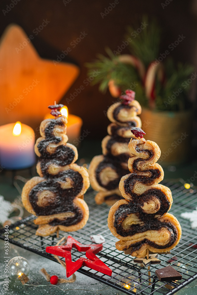 Christmas tree cinnamon cookies with decor on a black lattice on a green concrete background. Christmas sweets. Christmas tree cinnamon cookies with decor on a black lattice on a green concrete background. Christmas sweets.